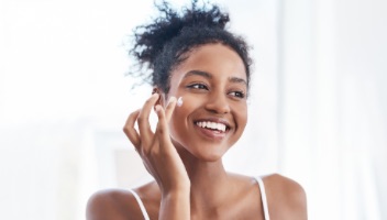 Woman applying face cream)
